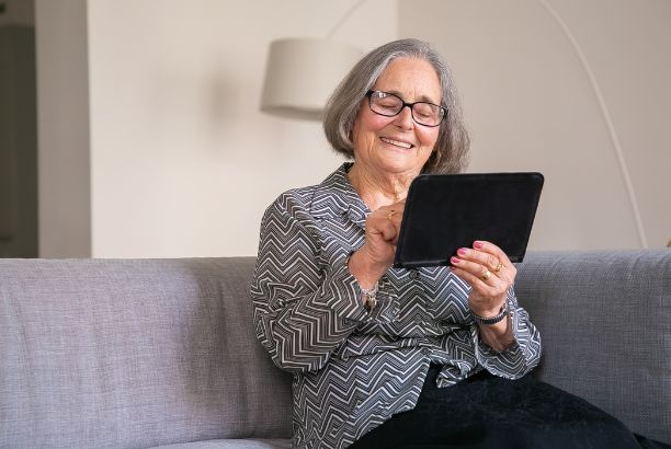 ALT: Persona mayor usando una tablet con apps abiertas en pantalla